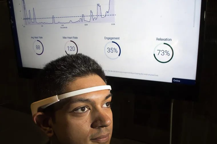 Eash Aggarwal, the front-end developer for user interface and user experience (UI/UX) for NeuroFlow, wears a bluetooth EEG device to measure physiologic metrics such as heart rate, engagement and relaxation (as shown on the screen behind).