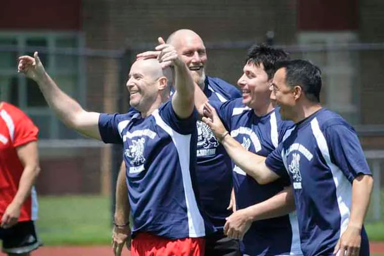 Willingboro's Jeremy Cote (left) is congratulated by teammates after scoring the first goal of the game during the reunion soccer game with Kennedy at Carl Lewis Stadium at Willingboro High School. ( RON TARVER / Staff Photographer ) May 17 2014