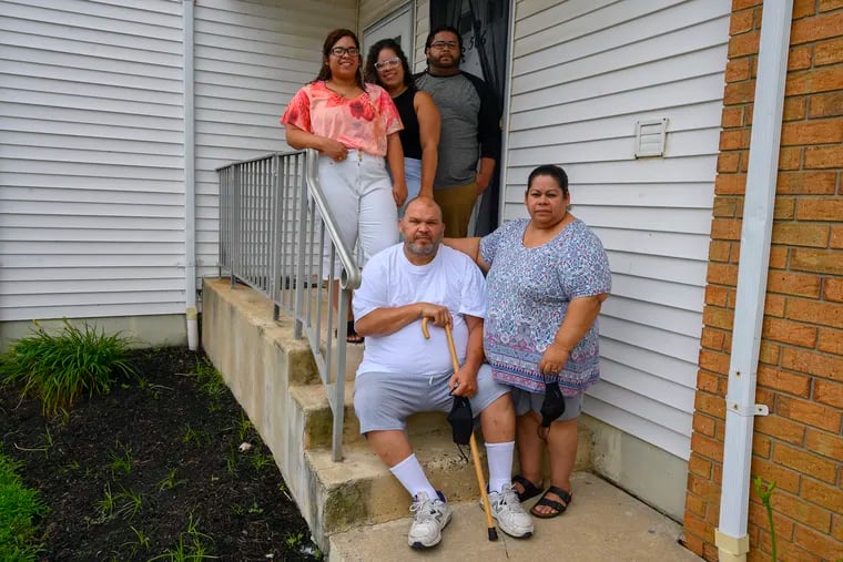 Former COVID-19 patient Radames Plaza (front left) and his wife Judy pose on the front stoop of their Lumberton, NJ home with children (L to R, back) Yasmeen, Jocelyn, and Radames, August 6, 2020.  Avi Steinhardt / For the Inquirer
