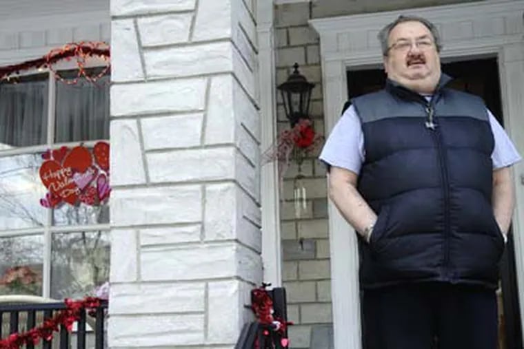 Santino DiBruno stands outside his South Philadelphia home on Valentine's Day. Rowhouses on the block were decorated for the holiday. (Caroline Morris / Staff Photographer )