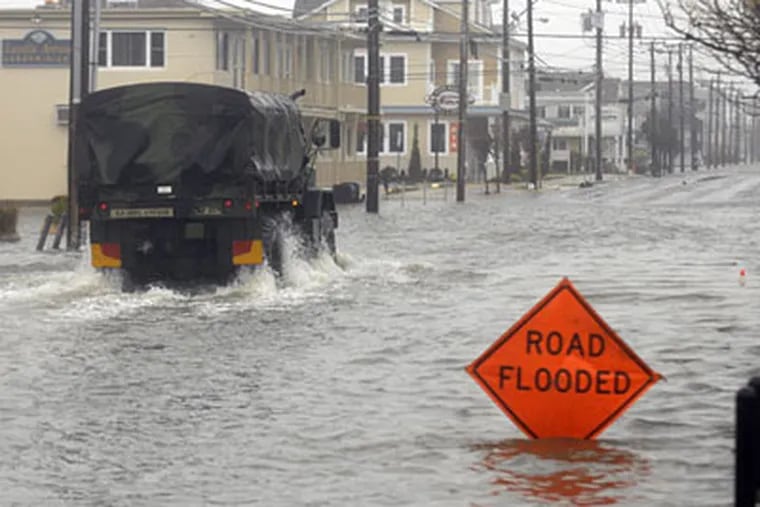 A military vehicle makes its way down a flooded Landis Avenue in Sea Isle City. (Ron Tarver / Staff Photographer)