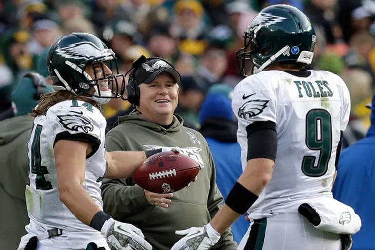 Riley Cooper (14) is congratulated by Nick Foles (9) and head coach Chip Kelly Cooper's touchdown catch during the second half of an NFL football game against the Green Bay Packers Sunday, Nov. 10, 2013, in Green Bay, Wis. (Mike Roemer/AP)