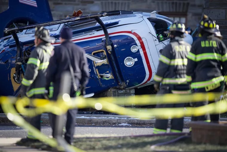 Firefighters gather at the scene after a medical helicopter crashes in the Drexel Hill section of Upper Darby Township in Delaware County, Pa. on Tuesday, Jan. 11, 2022.