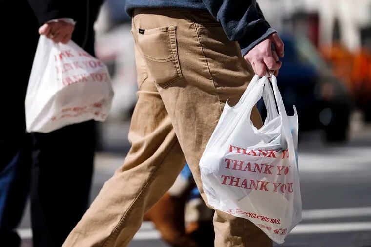 File: Pedestrians carry plastic bags in Philadelphia.