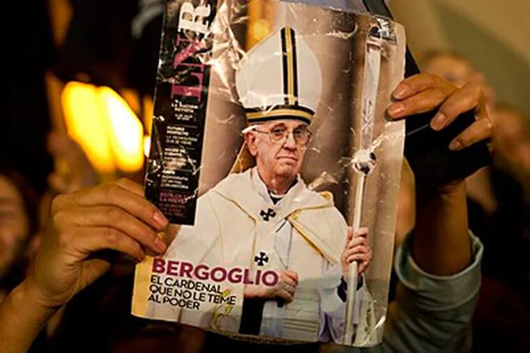 A worshiper holds up the front page of a magazine showing a photograph of Jorge Mario Bergoglio with the title in Spanish "Bergoglio. The cardinal who isn't afraid to face power" during celebrations outside the Metropolitan Cathedral in Buenos Aires, Argentina, Wednesday, March 13, 2013. Latin Americans reacted with joy on Wednesday at news that Bergoglio was elected pope. Bergoglio, who chose the name Pope Francis, is the first pope ever from the Americas.  (AP Photo/Victor R. Caivan