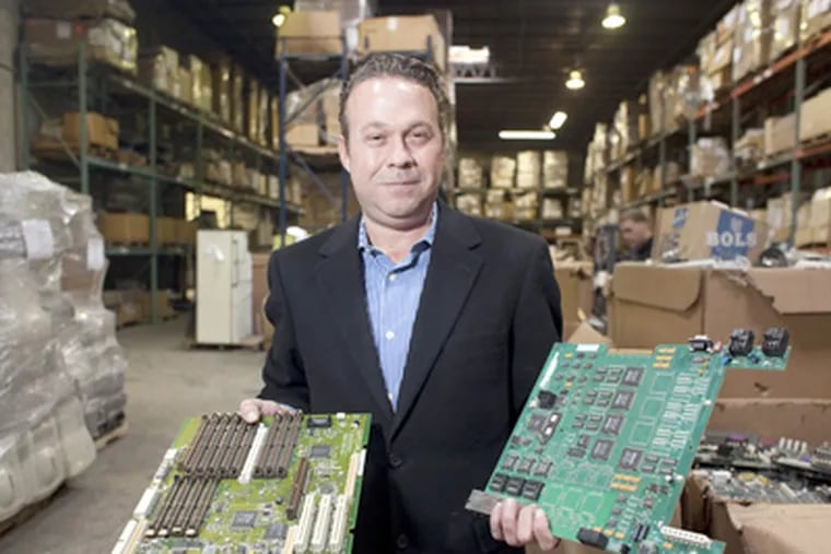 At eForce Compliance on Grays Ferry Avenue, managing director Charles Nygard holds circuit boards. (Ed Hille / Staff Photographer)