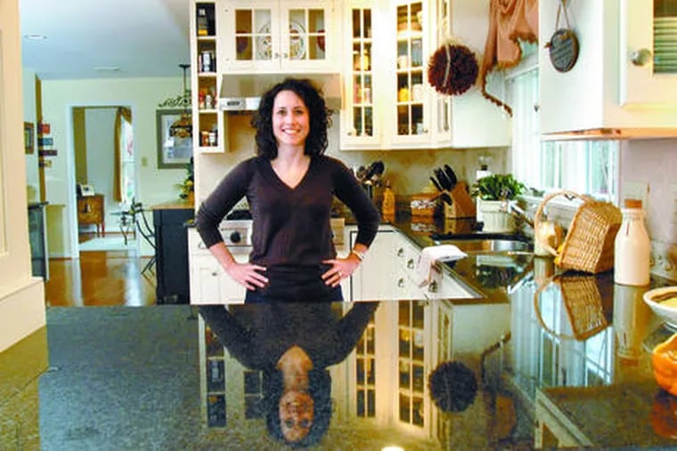 Jaclyn Kirchhoff stands in the remodeled kitchen of her Moorestown home. She and her husband, Michael, ditched yellow cabinets and pink stovetop for features including granite countertops and wine refrigerator.