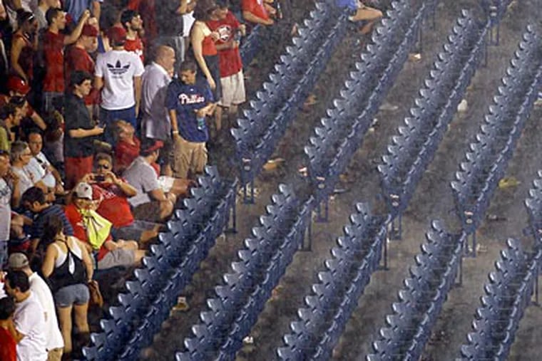 Phillies fans wait out the rain delay at Citizens Bank Park on Thursday night. (Yong Kim/Staff Photographer)