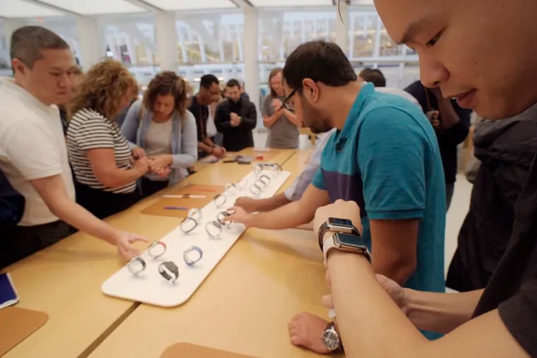 In this Sept. 21, 2018, file photo customers look at new Apple watches including the Series 4 at an Apple store in New York.