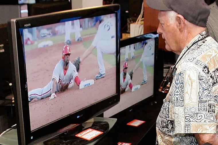 A man watches the Phillies play while shopping for a new television. (AP Photo/Paul Sakuma)