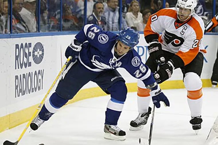 Chris Pronger defends Martin St. Louis in his return from an eye injury. (Chris O'Meara/AP)
