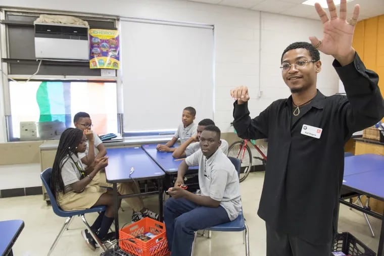ArtistYear Fellow Aqil Rogers explains to Harrity School students in West Philadelphia how to assemble a contact microphone from component parts.