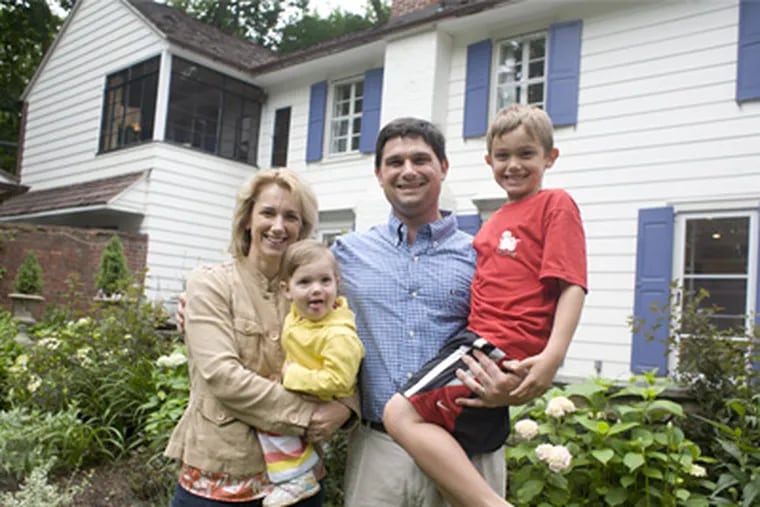Bethany Burt and Lee Dinenberg stand outside their home with children Stowe [right] and Eliza. The couple's renovations to the 100-year-old home included adding 3,000 square feet. (Ed Hille / Staff Photographer)