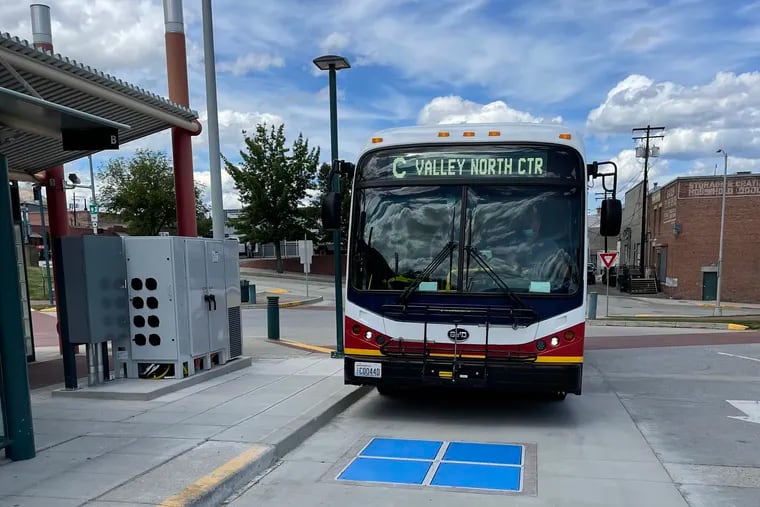 An electric transit bus in Wenatchee, Wash., approaches a wireless charging unit embedded in the ground on June 9, 2021.
