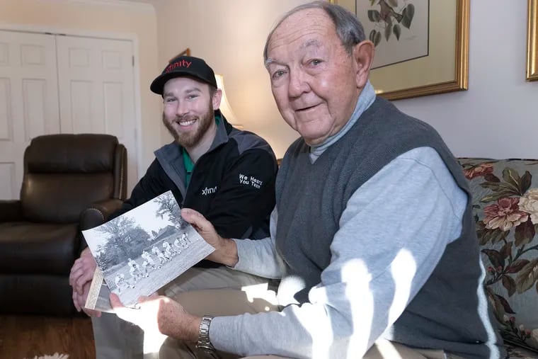 Tyler Vanderslice (left) and former Upper Dublin High School football coach John Pavlick look at old photographs of Vanderslice's father, Jack.