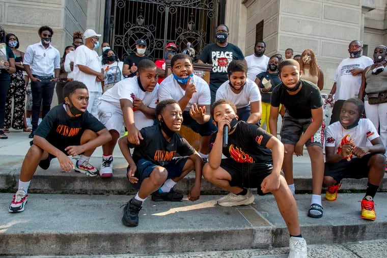 The Young Flames, a group of rappers aged 8-12 from South Philadelphia, sing as City Councilmember Kenyatta Johnson (rear in Vote mask) hosts a rally to end gun violence at City Hall on Aug. 10, 2020.