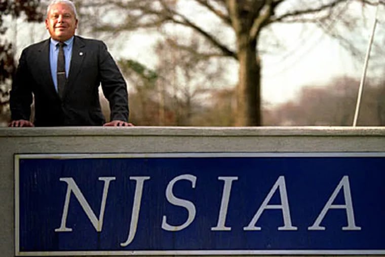 Former executive director Boyd Sands stands behind an NJSIAA sign at the organization’s offices in 1993. (Staff file photo)