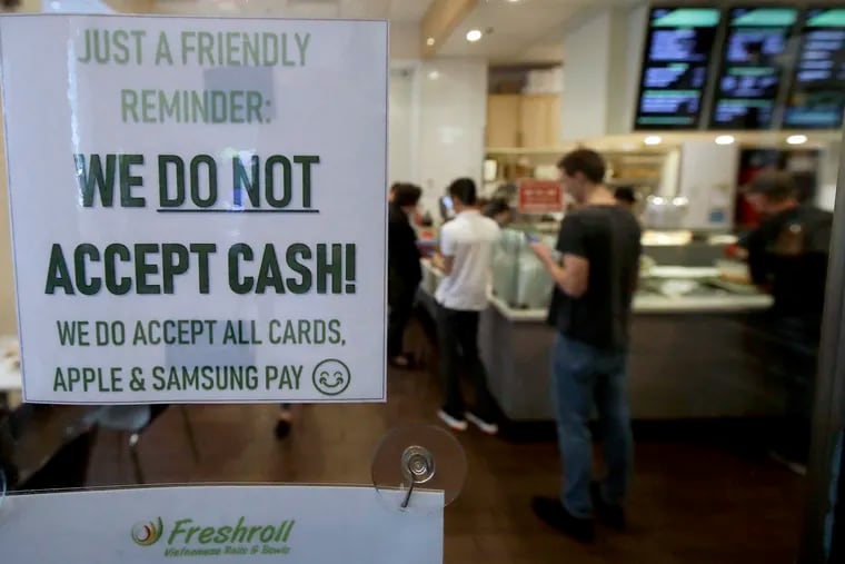 FILE photo shows a sign posted on a door alerting customers that cash is not accepted at Freshroll Vietnamese Rolls and Bowls in San Francisco.