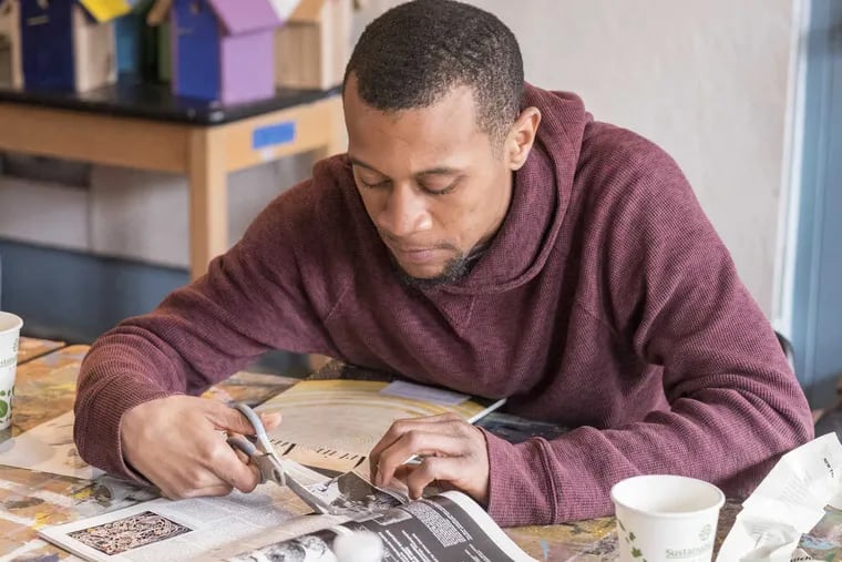 Kevin Burbage cuts out material for a collage as part of the Mural Arts Program "Voices," focused on promoting art to those affected by incarceration.