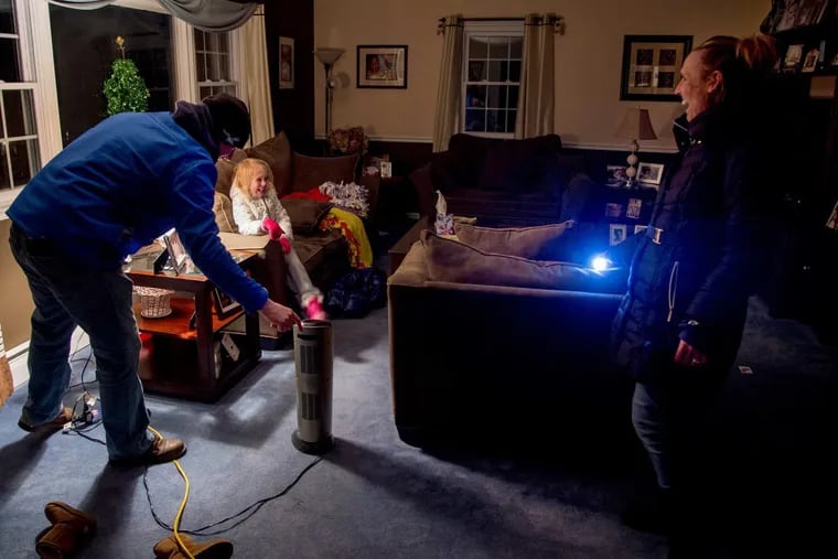 After four days without electricity, 6-year-old Audrey Mohr reacts as her father, Joe, turns on a light and a space heater after hooking up a new generator. Her mother, Michele, got the generator on Monday. Their street, the 700 block of Devon Lane in Wallingford, had a huge tree go down in Friday’s storm, taking power lines with it.