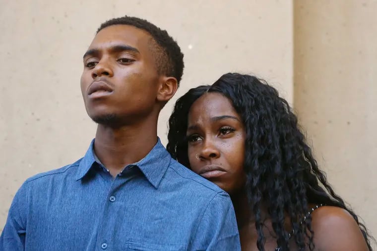 Dravon Ames, left, and Iesha Harper pause as they listen to a question during a news conference at Phoenix City Hall, Monday, June 17, 2019, in Phoenix. Ames and his pregnant fiancée, Harper, who had guns aimed at them by Phoenix police during a response to a shoplifting report say they don't accept the apologies of the city's police chief and mayor and want the officers involved to be fired.(AP Photo/Ross D. Franklin)