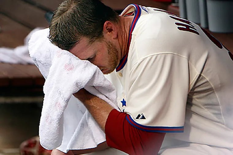 Roy Halladay wipes his face after he was pulled from the game in the sixth inning. (David Maialetti / Staff Photographer)