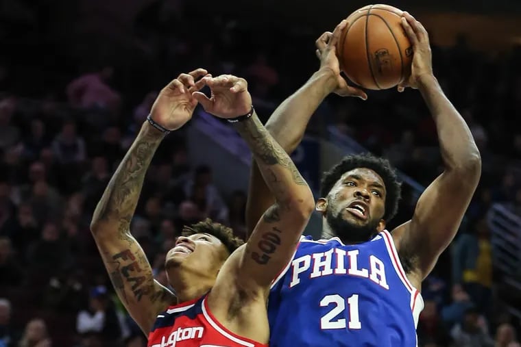 Sixers’ center Joel Embiid grabs a rebound from Wizards’ forward Kelly Oubre Jr. during the second quarter at the Wells Fargo Center on Wednesday.