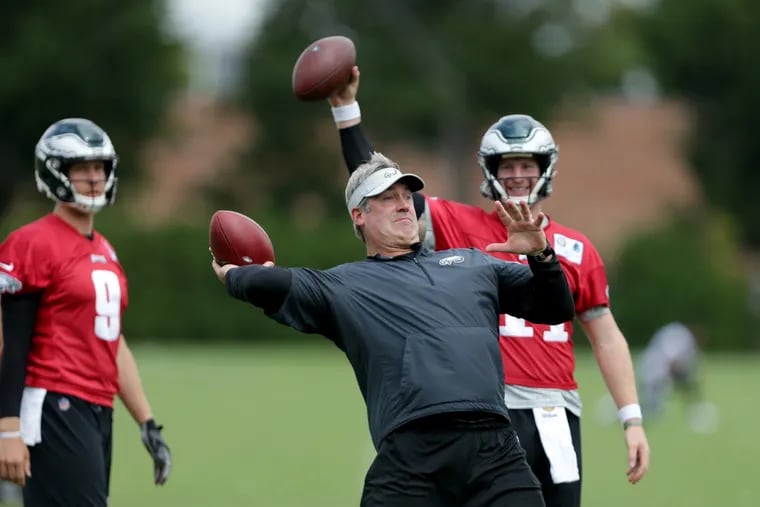 Eagles coach Doug Pederson, center, takes a turn throwing with Nick Foles, left, and Carson Wentz, right, during the Eagles practice at the NovaCare Complex in Philadelphia, PA on August 21, 2018. DAVID MAIALETTI / Staff Photographer