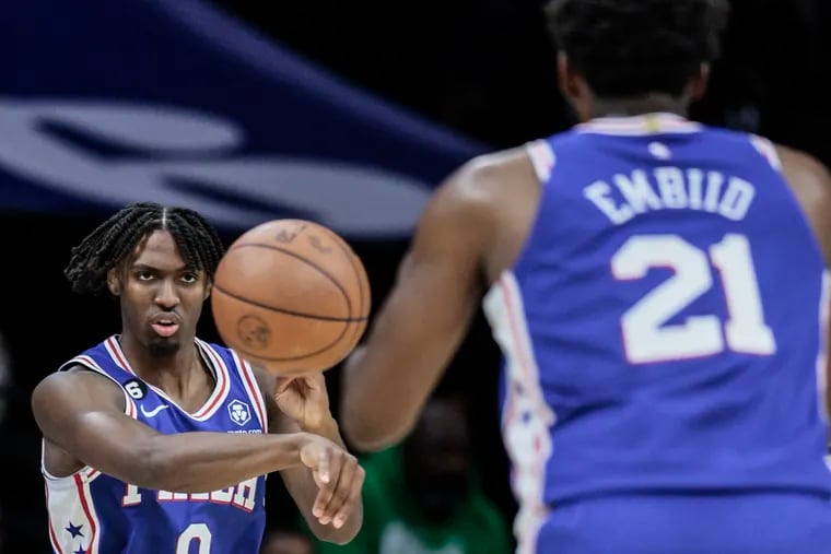 The Sixers' Tyrese Maxey throws a pass to teammate Joel Embiid while playing the Pacers at the Wells Fargo Center.