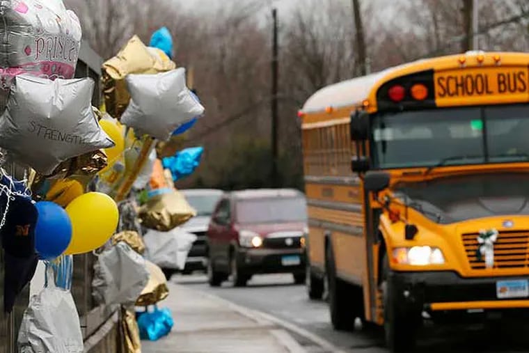 A school bus rolls toward a memorial Dec. 18 in Newtown , Conn., for victims in the Sandy Hook Elementary School shooting. (Associated Press)