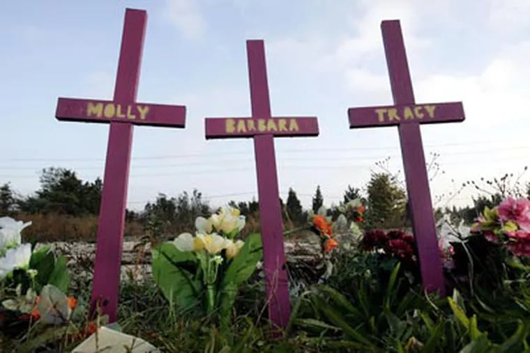 In this Wednesday, Nov. 14, 2007 photograph, three crosses stand, surrounded by flowers, in Egg Harbor Township, not far from the area where nearly a year ago, four Atlantic City-area prostitutes were found slain. (AP Photo/Mel Evans,file)