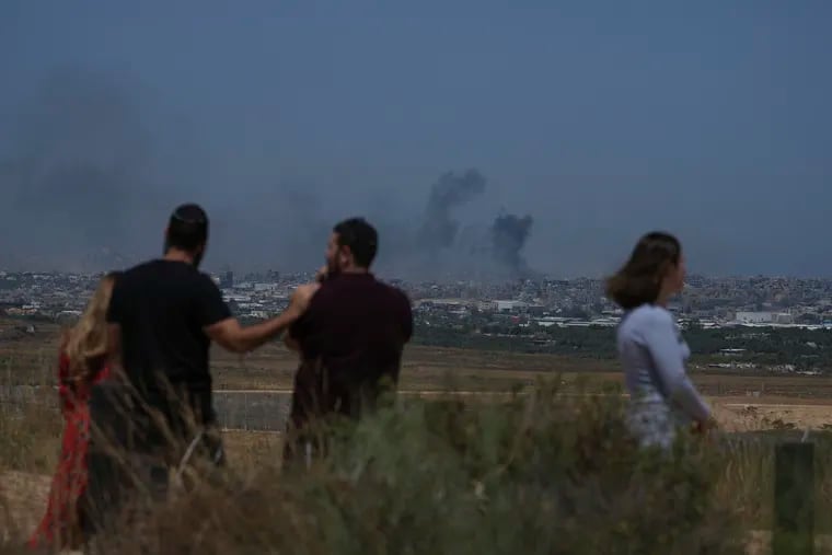 People watch smoke rising to the sky after an explosion in the Gaza Strip, as seen from southern Israel.