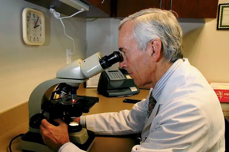 In this undated photo, Stanley Fineman looks through a microscope at Atlanta Allergy & Asthma Center in Atlanta to examine pollen.