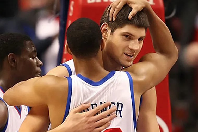 Evan Turner embraces Nikola Vucevic after the 76ers' win over the Wizards. (Steven M. Falk/Staff Photographer)
