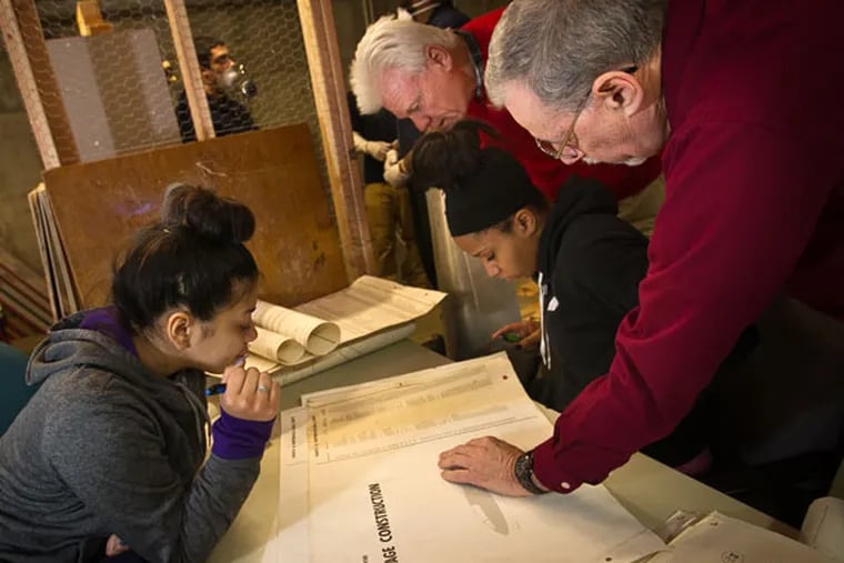 In a program to broaden horizons, students in Camden are building a plane from a kit. Ashley Gascot (left) and Ashley Williams look over an inventory list with Ira Weissman (foreground) and Don Powell. (ALEJANDRO A. ALVAREZ / Staff Photographer)