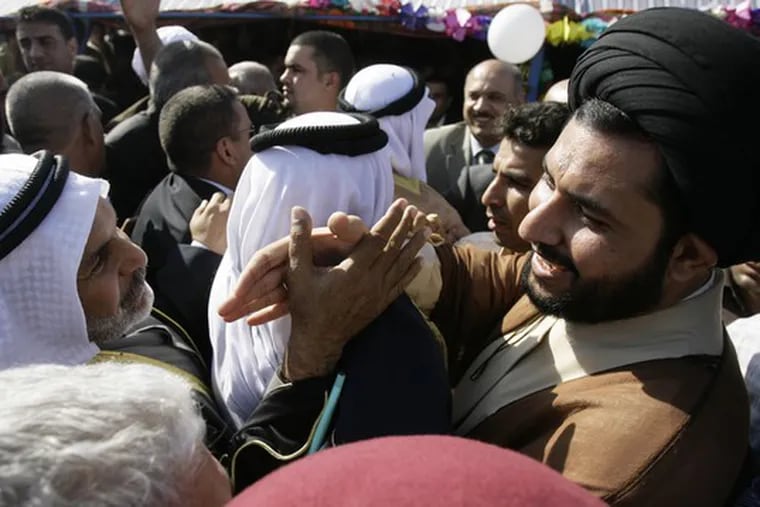 An Iraqi Sunni (left) and Shiite shake hands during an opening ceremony for the Imams Bridge in Baghdad. The bridge, barricaded three years ago, was reopened last month.