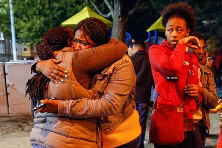 Family members Vanessa Oquendo (left) and Danae Mitchell embrace as Kiae George looks on during a vigil for Caleer Miller.
