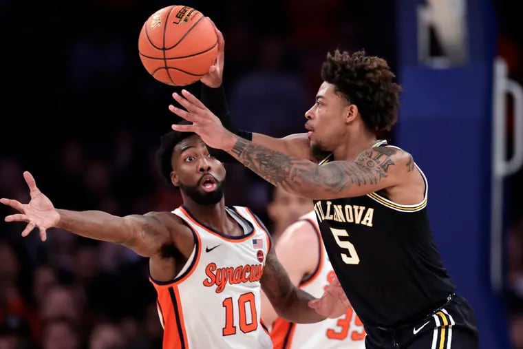 Villanova guard Justin Moore passes around Syracuse guard Symir Torrence (10) during the first half of an NCAA college basketball game in the Jimmy V Classic Tuesday, Dec. 7, 2021, in New York. (AP Photo/Adam Hunger)