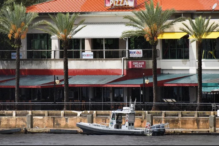 Law enforcement boats patrol the St. Johns River at The Jacksonville Landing after a mass shooting during a video game tournament at the riverfront mall.