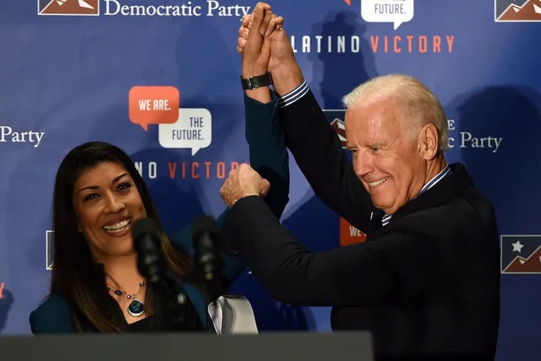 Then-Democratic candidate for lieutenant governor and Nevada Assemblywoman Lucy Flores, left, introduces U.S. Vice President Joe Biden at a get-out-the-vote rally at a union hall on Nov. 1, 2014 in Las Vegas, Nev. Flores wrote that she felt demeaned when Biden touched her offstage at a 2014 campaign rally.