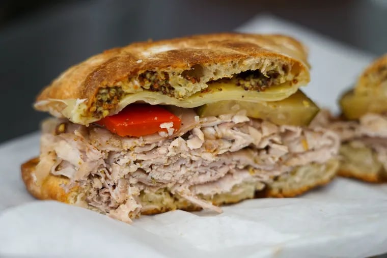The Cubano sandwich from Porco's Porchetteria layers herb-roasted pork and cracklings with whole grain mustard aioli, house giardiniera and Gruyere cheese on a ciabatta baked in-house by the Small Oven Pastry Shop.