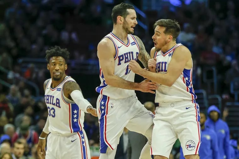 Sixers forward JJ Redick (center) celebrates a first-quarter three-point basket with teammates guard T.J. McConnell (right) and forward Robert Covington against the Orlando Magic on Saturday, November 25, 2017 in Philadelphia.