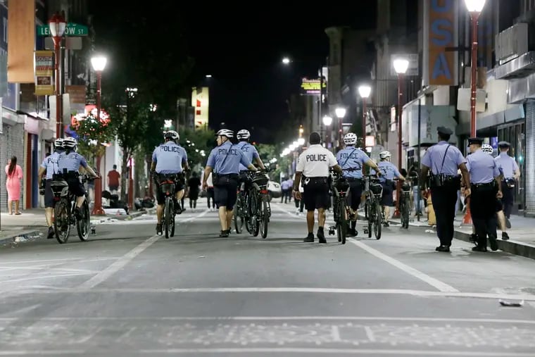 Philadelphia police encourage revelers to go home as they walk along South Street in July of 2019.