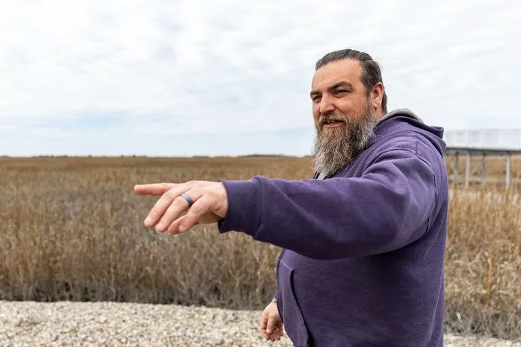 Shane Godshall, habitat restoration project manager for the American Littoral Society, points to where coir logs  — made of coconut husks — are being used to raise Thompsons Beach marsh and prevent erosion near the Delaware Bay in Cumberland County.