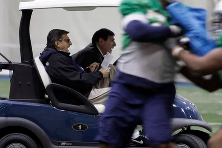 Penn State coach Joe Paterno (left) yells to players from a golf cart during practice for the Rose Bowl. The coach, who had hip-replacement surgery Nov. 23, says he is improving.