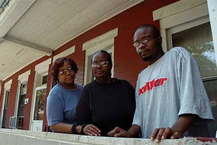 Brenda Carpenter (center), with her sister Verna Cotton and son Patrick Carpenter. She is trying to save her South Philadelphia home. (SARAH J. GLOVER / Inquirer)