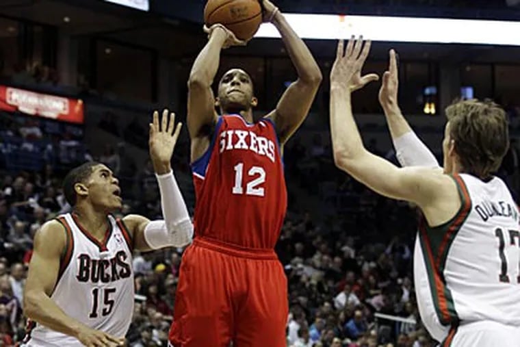 Sixers guard Evan Turner shoots between the Bucks' Tobias Harris and Mike Dunleavy in the first half. (Morry Gash/AP)
