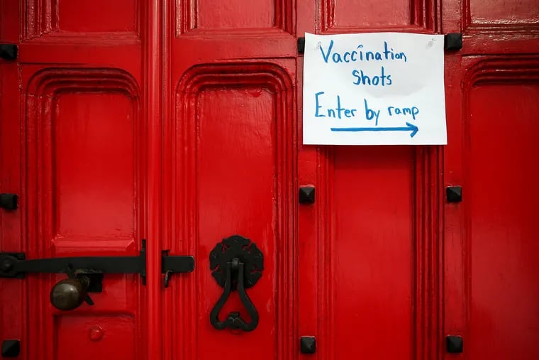 A sign points visitors to the Main Line Health vaccination clinic inside the African Episcopal Church of St. Thomas in Philadelphia on Feb. 10, 2021.