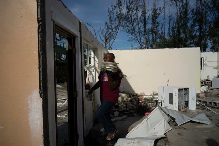 Mister Bolter recovers dishes from his son's home, destroyed by Hurricane Dorian in Pine Bay, near Freeport, Bahamas, Wednesday, Sept. 4, 2019. Rescuers trying to reach drenched and stunned victims in the Bahamas fanned out across a blasted landscape of smashed and flooded homes Wednesday, while disaster relief organizations rushed to bring in food and medicine.