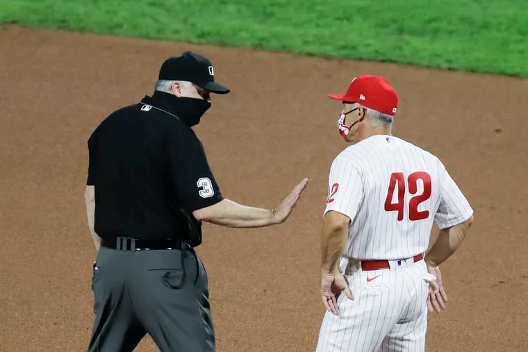 Umpire Bill Welke holds back Phillies manager Joe Girardi during the ninth inning against the Atlanta Braves on Sunday.